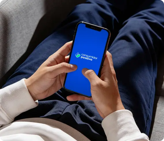 Pessoa deitada acessando o app da Consumidor Positivo
